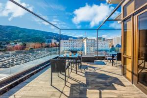 - un balcon avec une table et des chaises au-dessus d'un bâtiment dans l'établissement Cron Palace kosher Tbilisi Hotel, à Tbilissi
