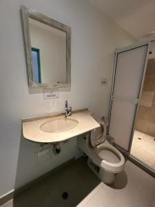 a bathroom with a sink and a toilet with a mirror at Hotel CastilloMar in Cartagena de Indias