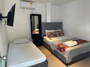 a bedroom with two beds and a mirror at Hotel CastilloMar in Cartagena de Indias
