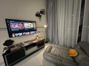 uma sala de estar com uma televisão de ecrã plano e uma cadeira em Gala City best place gala residence em Kuching