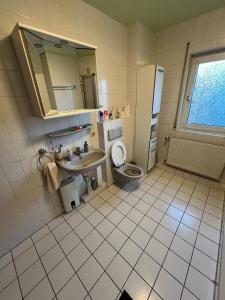 uma casa de banho com um lavatório, um WC e um espelho. em Guest house Offenbach em Bürgel