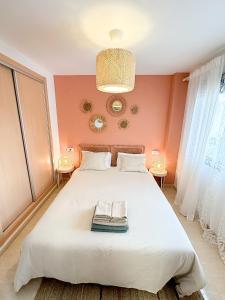 a bedroom with a large white bed with orange walls at Moderne, lumineux, balcon, piscine, parking in El Campello