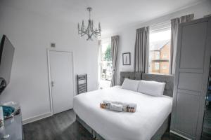 a bedroom with a large white bed with a chandelier at The Finsbury Guesthouse in London