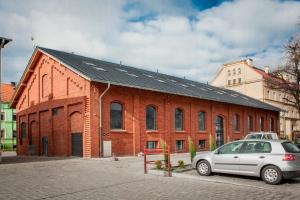 een auto geparkeerd voor een bakstenen gebouw bij CTKiR Browar Probus in Oława