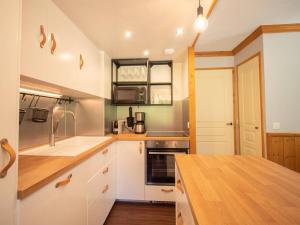 a kitchen with white cabinets and a wooden counter top at Grand appartement 5 chambres Valmorel, animaux acceptés, parking - FR-1-291-730 in Valmorel +5 photos