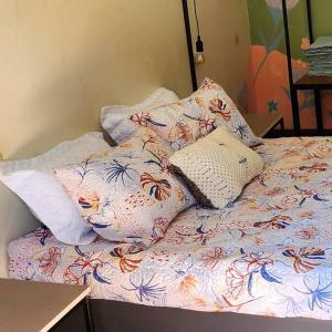 a bed with pillows on top of it at Apartamento na quadra da Praia de Piratininga in Niterói