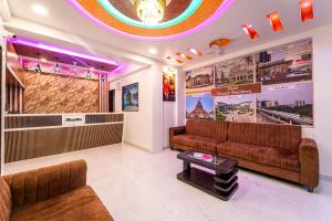 a waiting room with brown leather couches and a table at Treebo Trend Kharadi Residency - Near EON IT Park in Pune