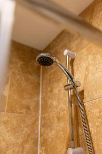 a shower head in a bathroom with a tile floor at Charming 5-Bedrooms in the Heart of Liverpool - By Resify in Liverpool
