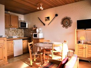 a kitchen with a table and chairs and a kitchen with a table and a kitchen at Appartement Auris, 1 pièce, 4 personnes - FR-1-297-16 in Auris