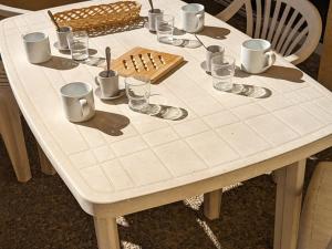 a white table with cups and glasses on it at Studio 4 Pers avec Loggia, Pieds des Pistes, Ascenseur et WIFI, Centre Station - FR-1-262-103 in Forest des Baniols