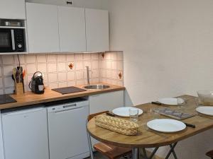 eine kleine Küche mit Tisch und Spüle in der Unterkunft Studio 4 Pers avec Loggia, Pieds des Pistes, Ascenseur et WIFI, Centre Station - FR-1-262-103 in Forest des Baniols
