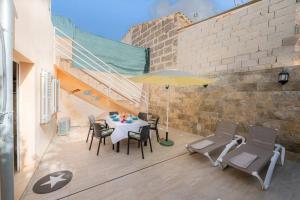 eine Terrasse mit einem Tisch, Stühlen und einem Sonnenschirm in der Unterkunft Casa Ca Na Xisca in Porreres