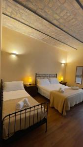 una camera con due letti, due lampade e un soffitto di Holiday Suite Roma a Roma