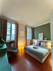 a bedroom with a bed and a desk and windows at MaïHomes - La Villa Marseillaise in Marseille