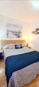 um quarto com uma cama com uma colcha azul e branca em CANDELARIA SOL Y MAR em Candelaria