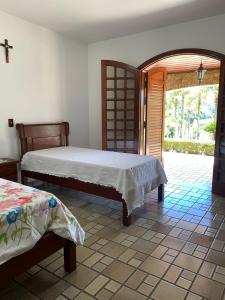 1 dormitorio con 2 camas y puerta abierta en Linda Chácara em Piracaia SP en Piracaia
