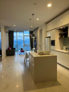 a large kitchen with a counter and a living room at Platinum Suites Kuala Lampur by Likehome in Kuala Lumpur