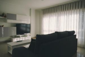 a living room with a couch and a television at Rosende VUT in Arzúa