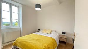 ein Schlafzimmer mit einem Bett mit einer gelben Decke in der Unterkunft La Pause Péronnaise - BY PRIMO C0NCIERGERIE in Péronne