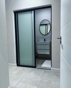a bathroom with a glass door with a mirror at Munyaka Lagoon Penthouse in Midrand