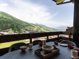 a table with bowls on it with a view of a mountain at Appartement Valmorel, 4 pièces, 8 personnes - FR-1-291-784 in Valmorel
