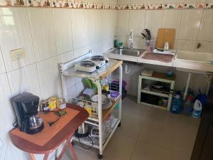 een kleine keuken met een wastafel en een fornuis bij Acogedora vivienda anexa en un barrio tranquilo in David
