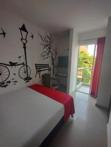 1 dormitorio con 1 cama con una bicicleta en la pared en HOTEL BELLAMAR, en Cartagena de Indias