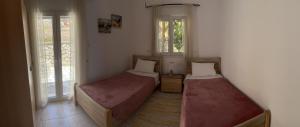 dwa łóżka w pokoju z dwoma oknami w obiekcie Villa-Skalia / Kalymnos House w mieście Kalimnos
