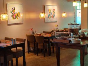 a dining room with tables and chairs and lights at Hotel Saint Vincent in Poeldijk