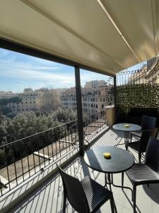 a balcony with tables and chairs and a view of a city at Re di Roma Rooftop in Rome