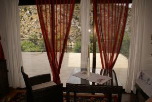 a table and chairs in front of a large window at Villa Velagic in Blagaj