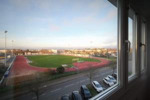 una finestra con vista su un parcheggio con auto di APPARTEMENT ARENA/ GROUPAMA STADIUM/ EUREXPO a Décines-Charpieu