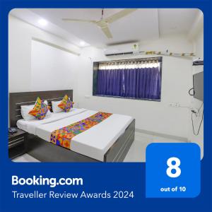 a hotel room with a bed and a window at FabHotel Villa 31 in Nagpur