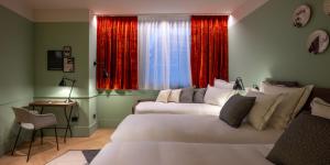 - une chambre avec 2 lits et une fenêtre avec des rideaux rouges dans l'établissement Urban Hive Milano, à Milan