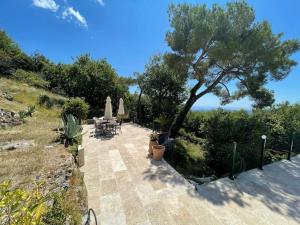 a patio with a tree and a table and chairs at Stunning Villa 5 bedroom Heaven on earth in Tourrettes-sur-Loup