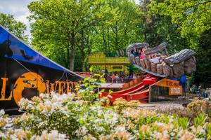 een achtbaan in een park met mensen erop bij Glamping Drouwenerzand - Danny's Lodge in Drouwen