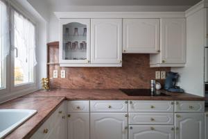 a white kitchen with white cabinets and a sink at APPARTEMENT ARENA/ GROUPAMA STADIUM/ EUREXPO in Décines-Charpieu