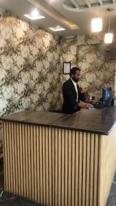 a man standing at a counter in an office at Hotel PAK Continental Multan in Multan