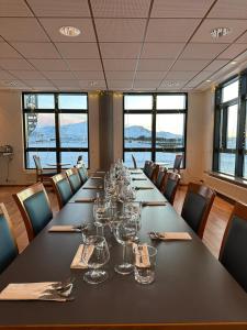 Adventure Hotel Hellissandur في هيلليساندور: قاعة المؤتمرات مع طاولة طويلة مع كؤوس النبيذ