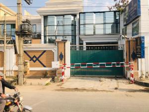 a man riding a motorcycle in front of a house at Hotel PAK Continental Multan in Multan