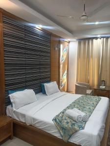 a bedroom with a large white bed with a window at Hotel Raj Mandir in Haridwār