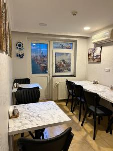 una sala de espera con mesas, sillas y pinturas en Timeks Suite Sultanahmet, en Estambul