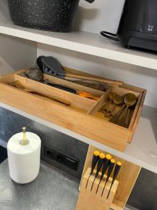 un cajón de madera con cuchillos y otros utensilios de cocina en Premium Apartment in quiet & historical area, en Riga