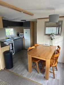 a kitchen and dining room with a wooden table and chairs at Static Mobile home set in our 20 acres of farmland in Horspath