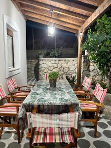 stół i krzesła na patio z kamienną ścianą w obiekcie Villa-Skalia / Kalymnos House w mieście Kalimnos