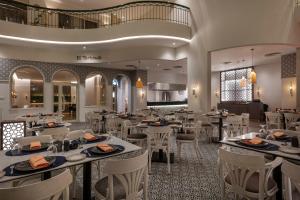 Steigenberger Nile Palace Luxor - Convention Center في الأقصر: غرفة طعام مع طاولات وكراسي بيضاء