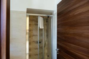 bagno con doccia e porta in vetro di La Villetta Food & Drink Rooms for Rent - No Reception - a L'Aquila