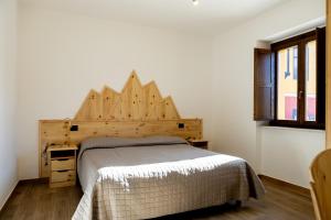 una camera con letto e testiera in legno di La Villetta Food & Drink Rooms for Rent - No Reception - a L'Aquila