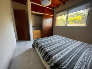 1 dormitorio con 1 cama grande y ventana en Ayres Pampa II Pa en Las Gaviotas