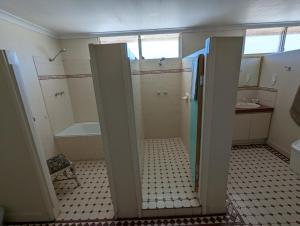 a bathroom with a shower and a tub and a sink at Toodyay Hotel in Toodyay